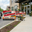 Custom yard signs with stakes outside a local business storefront, featuring 24x18 double-sided weatherproof signs for advertising, promotions, and customer visibility.